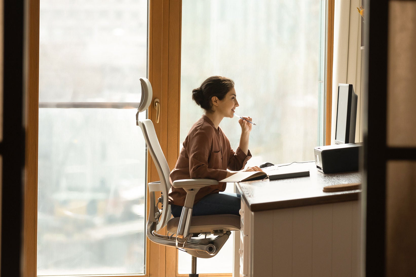 Seated job seeker browsing career opportunities on her PC.